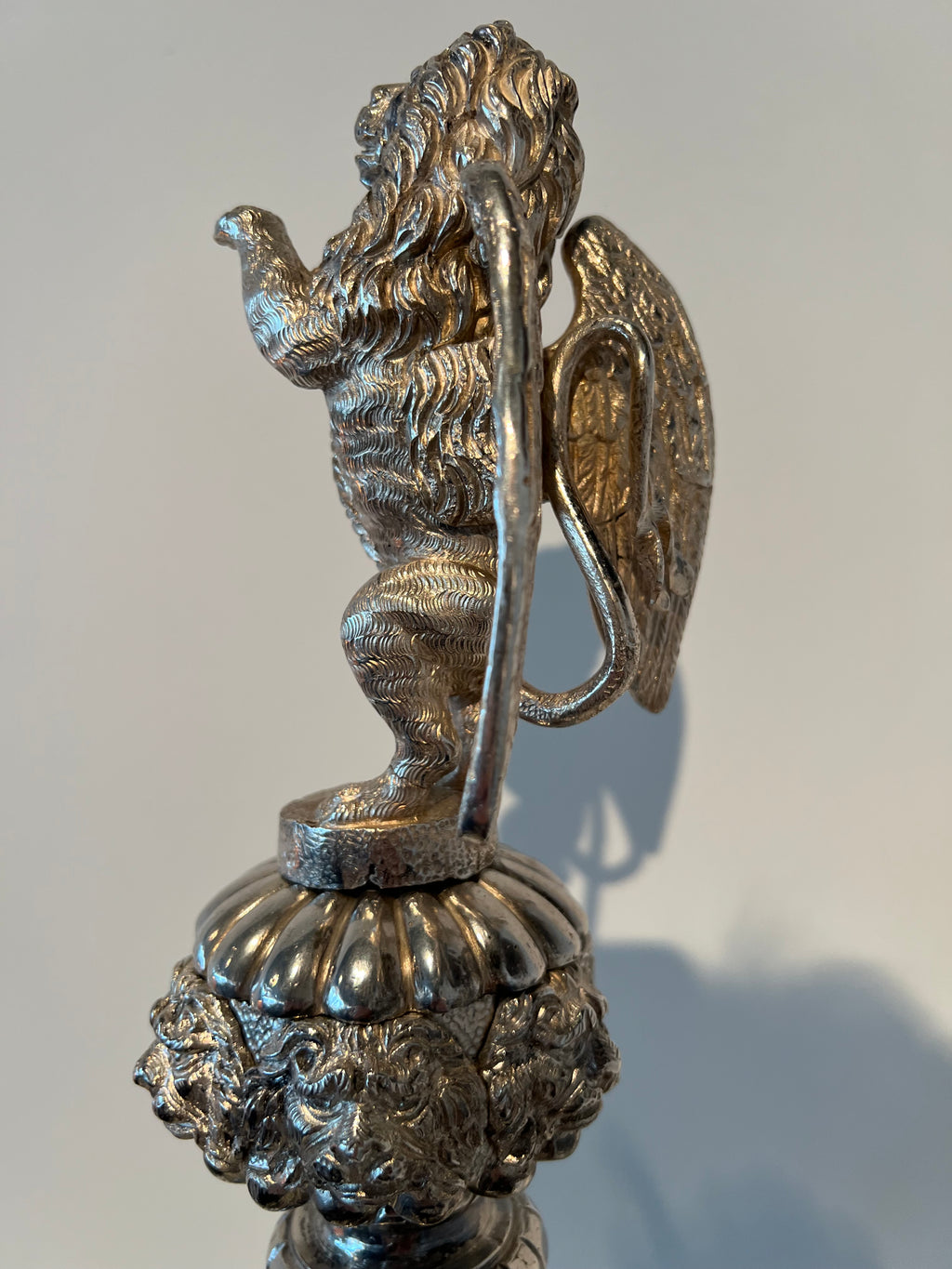 Paar monumentale zilveren andirons met gevleugelde leeuwen