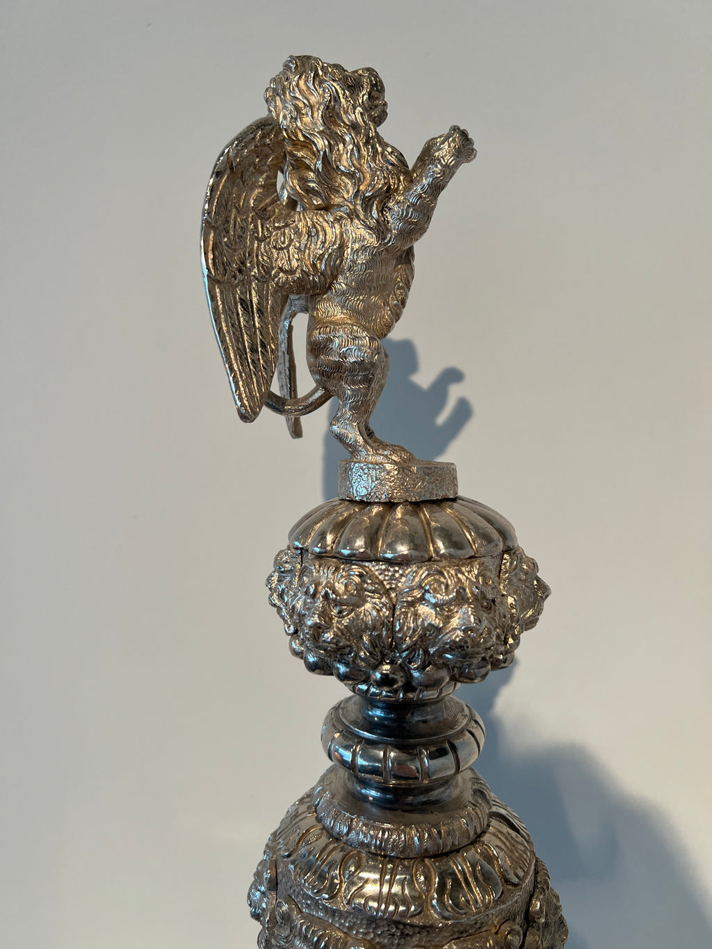 Paar monumentale zilveren andirons met gevleugelde leeuwen