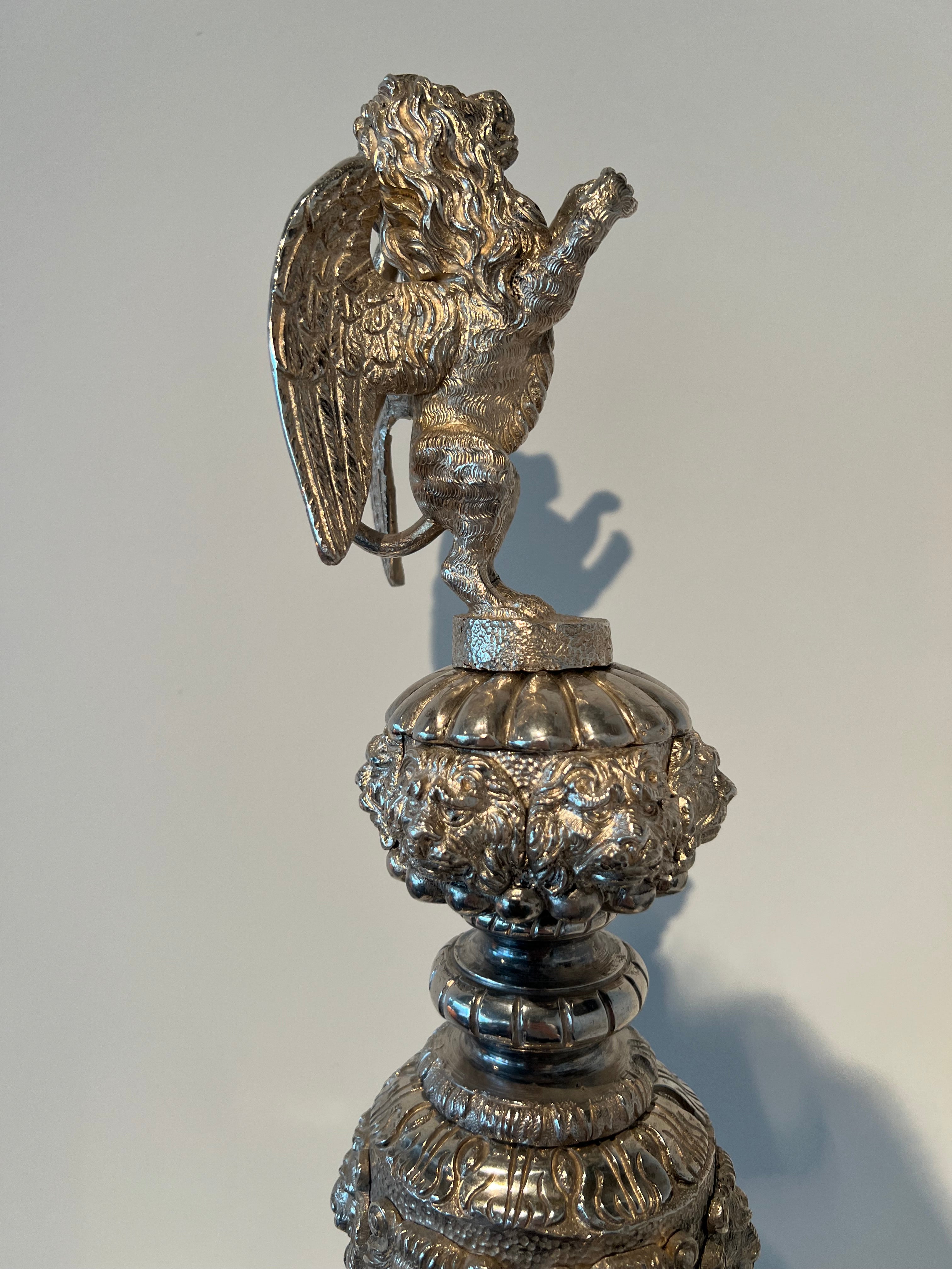 Paar monumentale zilveren andirons met gevleugelde leeuwen