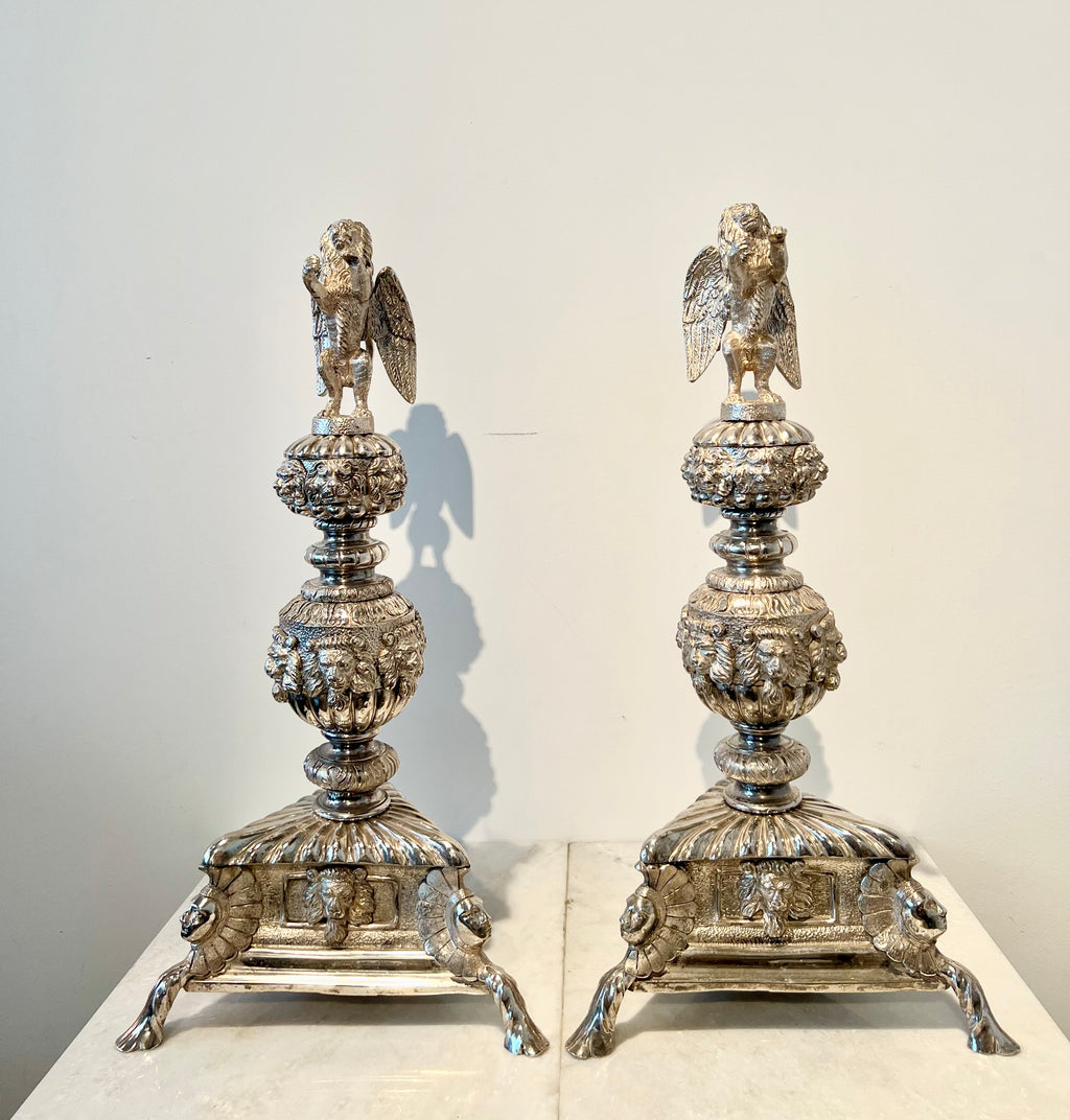 Paar monumentale zilveren andirons met gevleugelde leeuwen