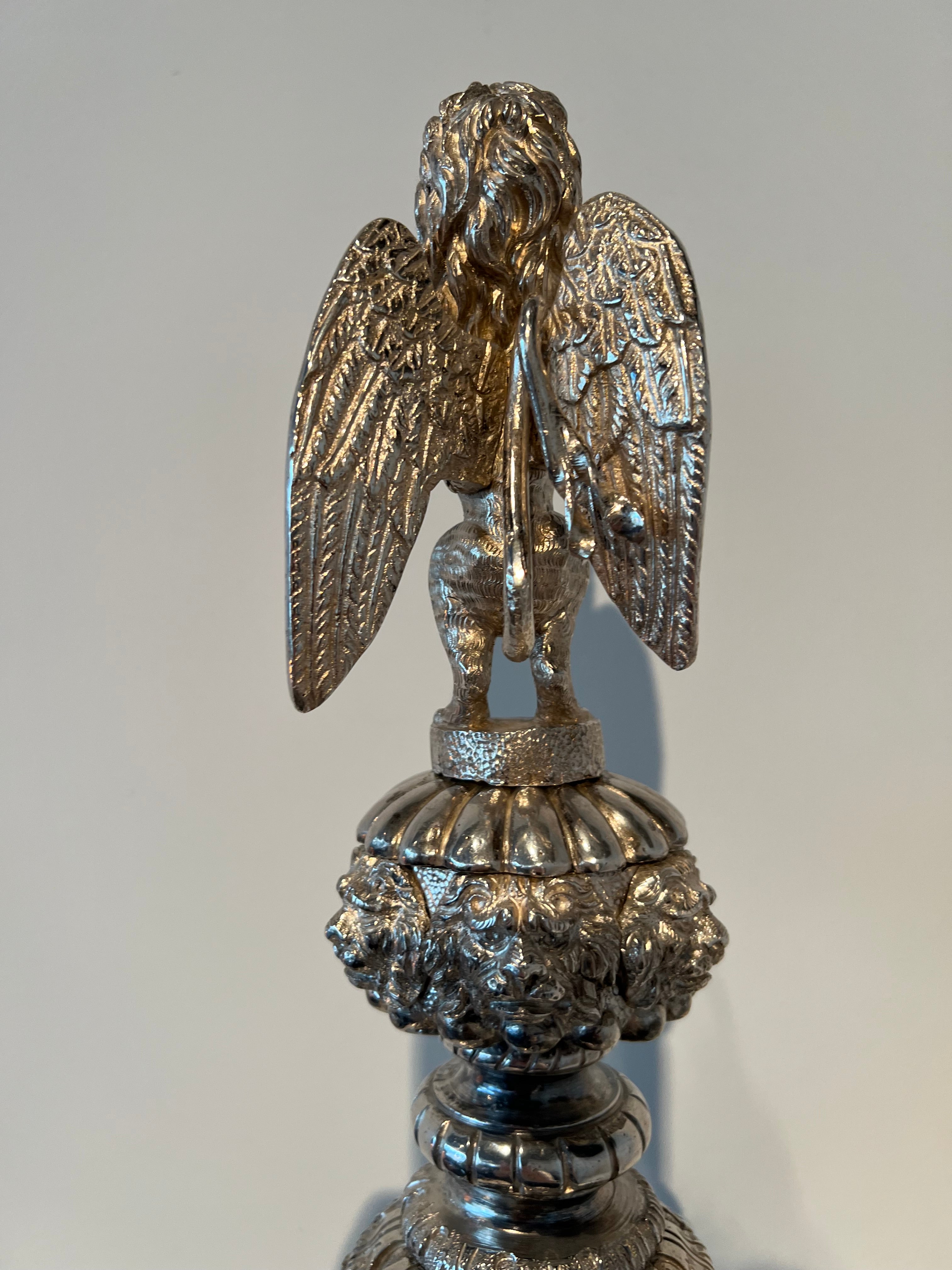 Paar monumentale zilveren andirons met gevleugelde leeuwen