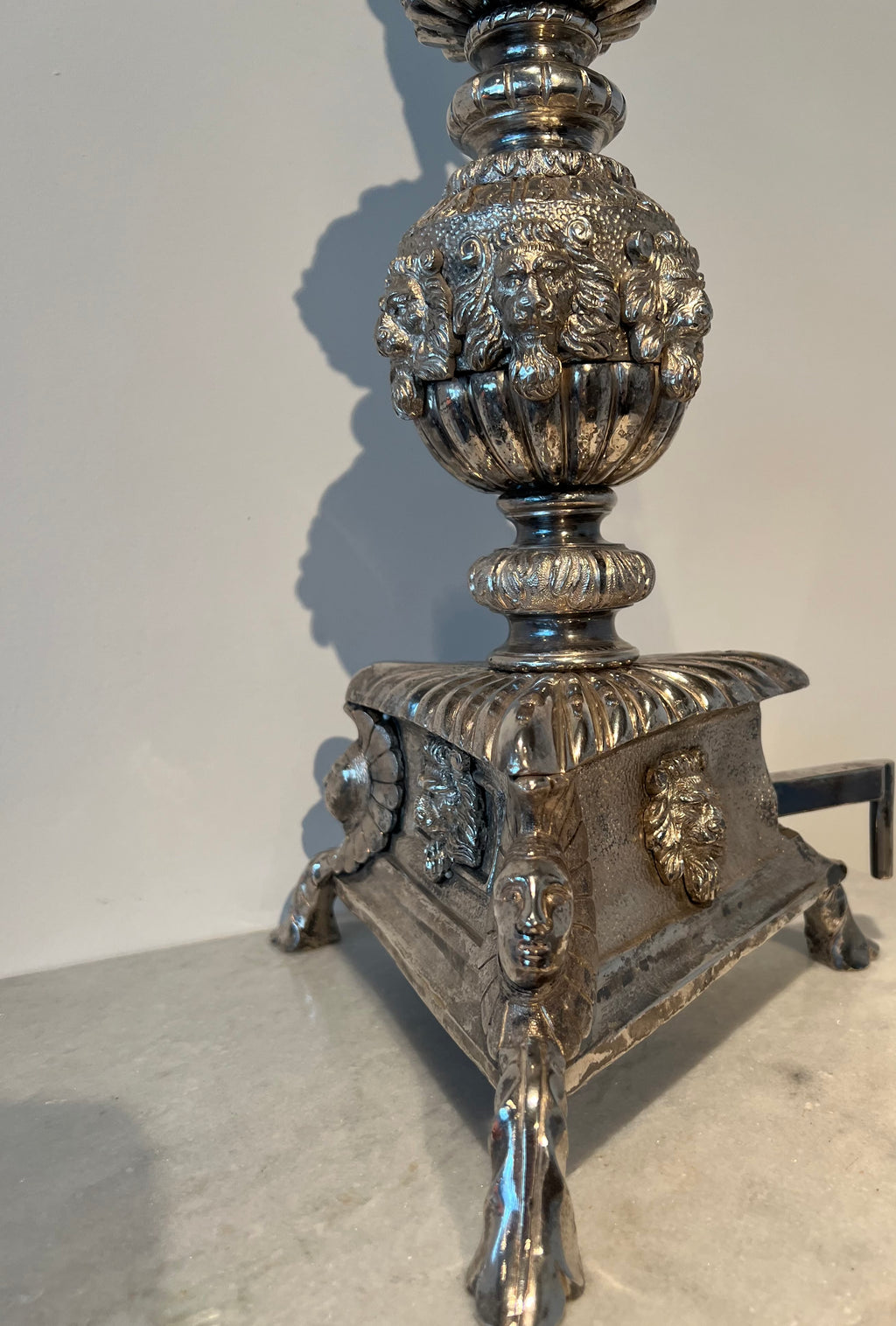 Paar monumentale zilveren andirons met gevleugelde leeuwen