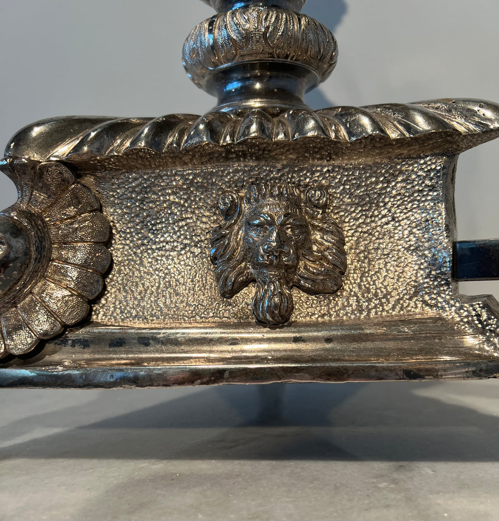 Paar monumentale zilveren andirons met gevleugelde leeuwen