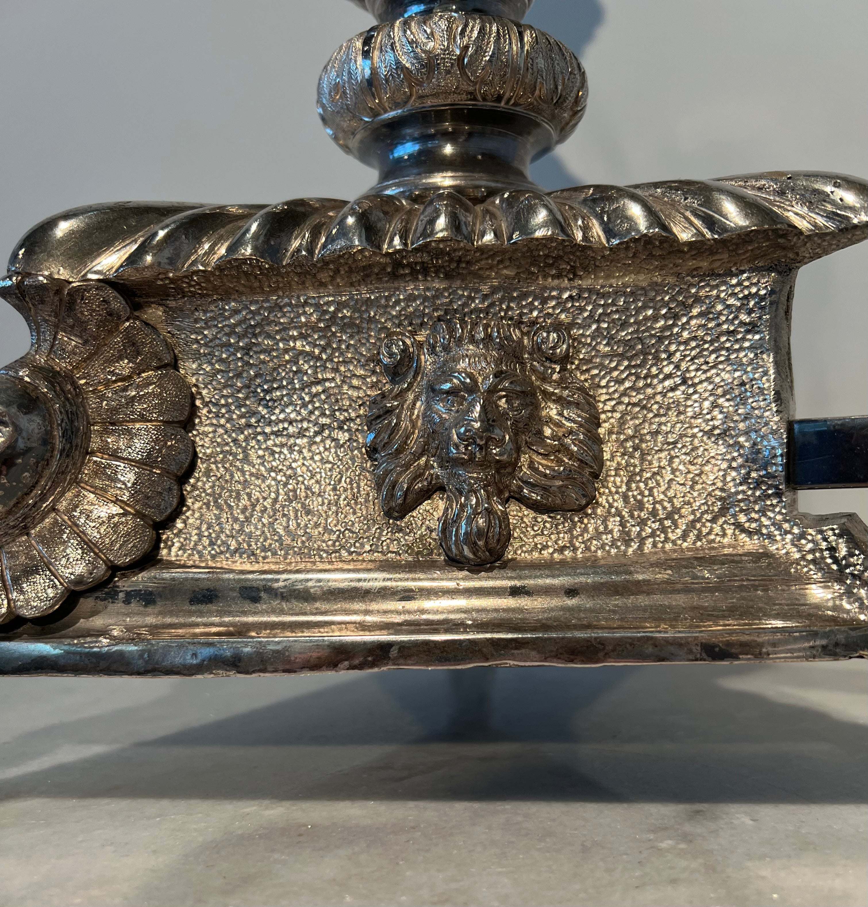 Paar monumentale zilveren andirons met gevleugelde leeuwen