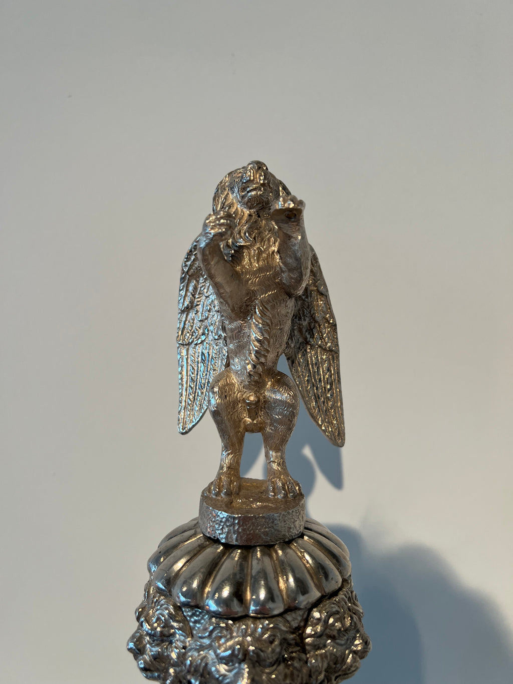 Paar monumentale zilveren andirons met gevleugelde leeuwen