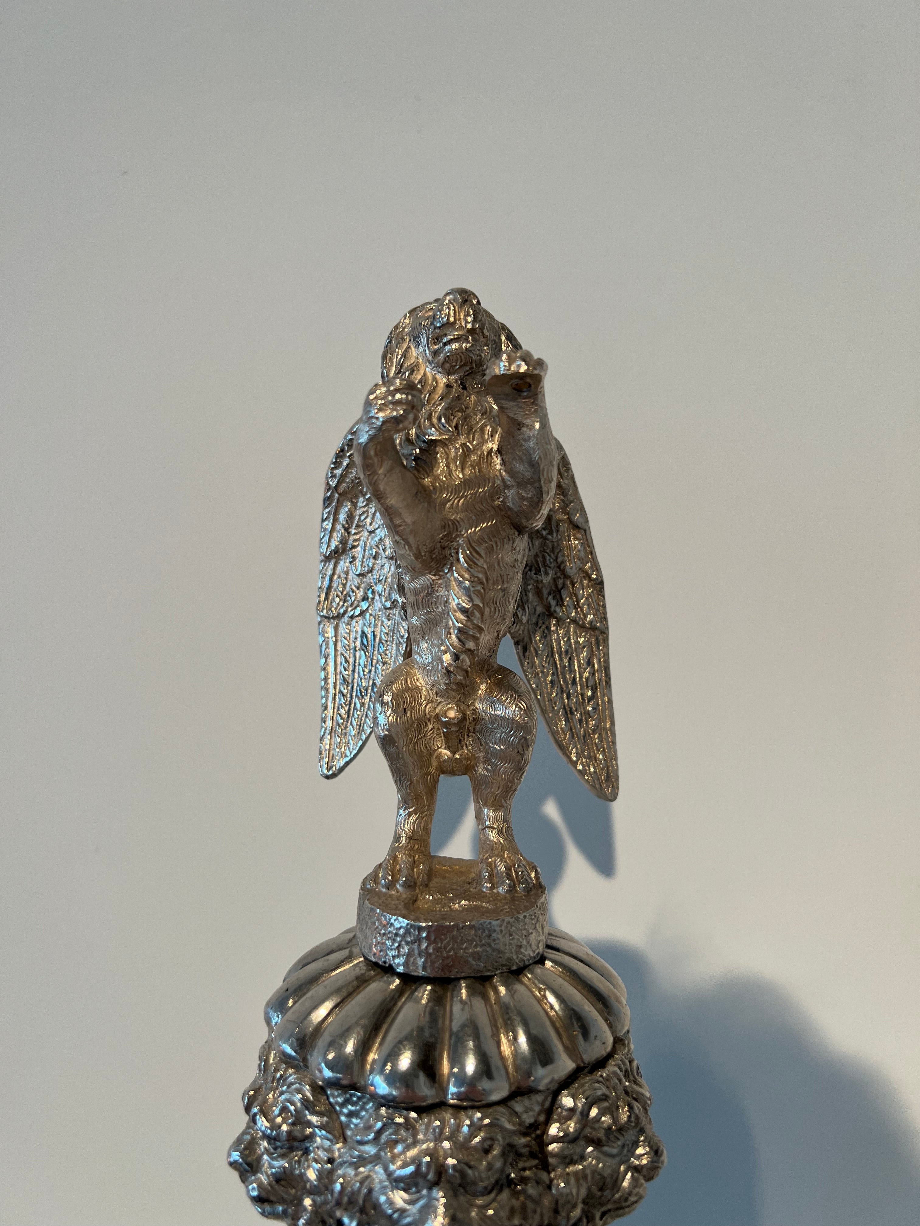 Paar monumentale zilveren andirons met gevleugelde leeuwen