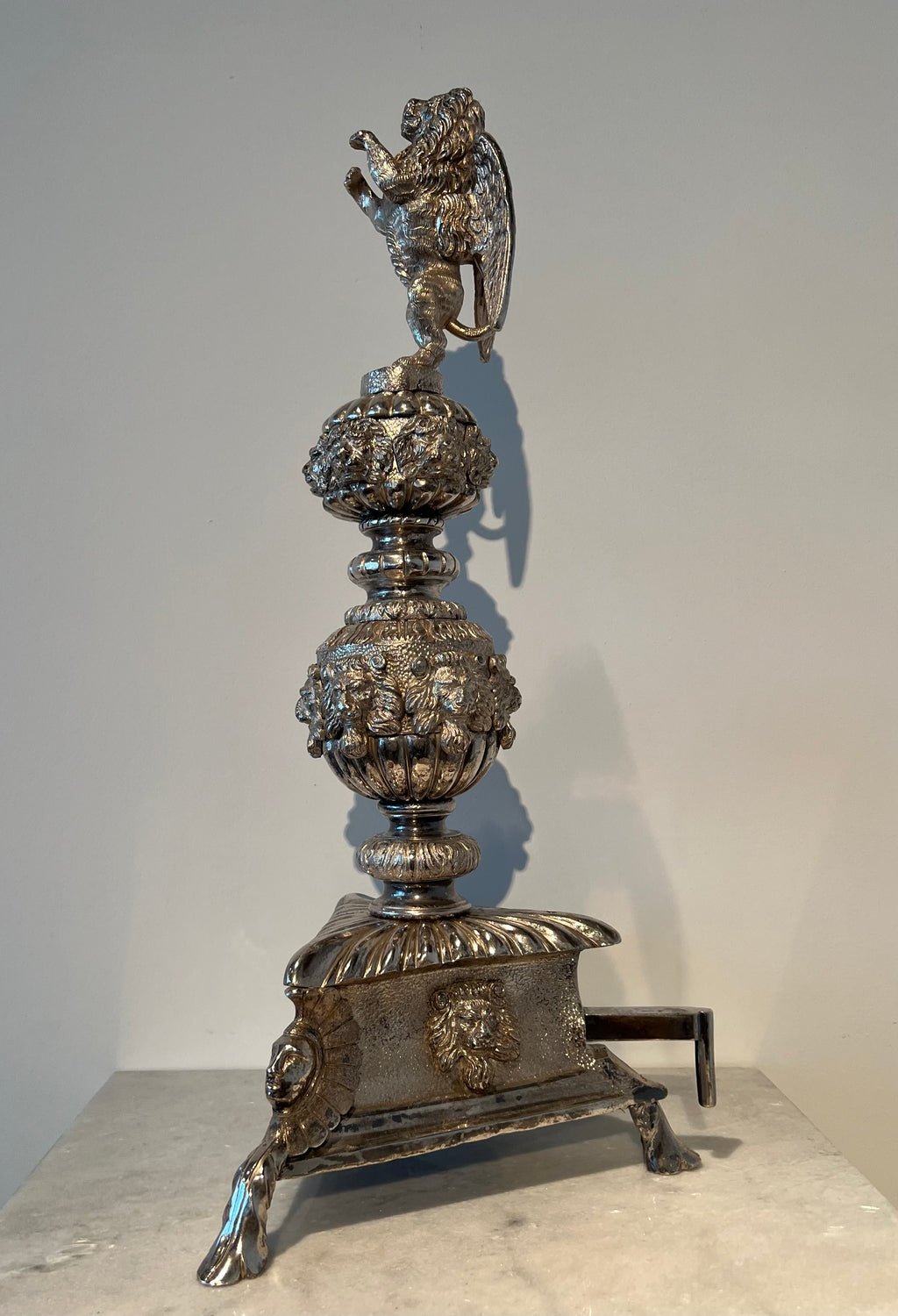 Paar monumentale zilveren andirons met gevleugelde leeuwen